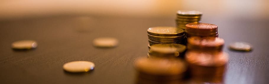 Close-up of stacked coins on a dark surface