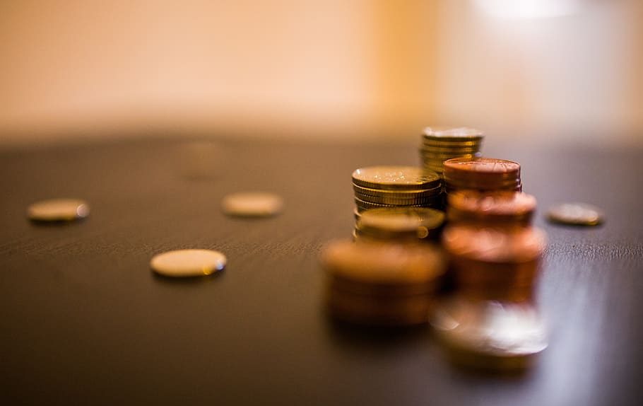 Close-up of stacked coins on a dark surface